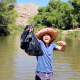 Isaac Dudley picks up trash in the Verde River