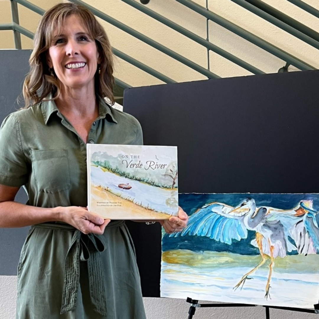 Author Phoebe Fox of Mamafox Books Author Phoebe Fox holding the book "On the Verde River" with a watercolor heron beside her