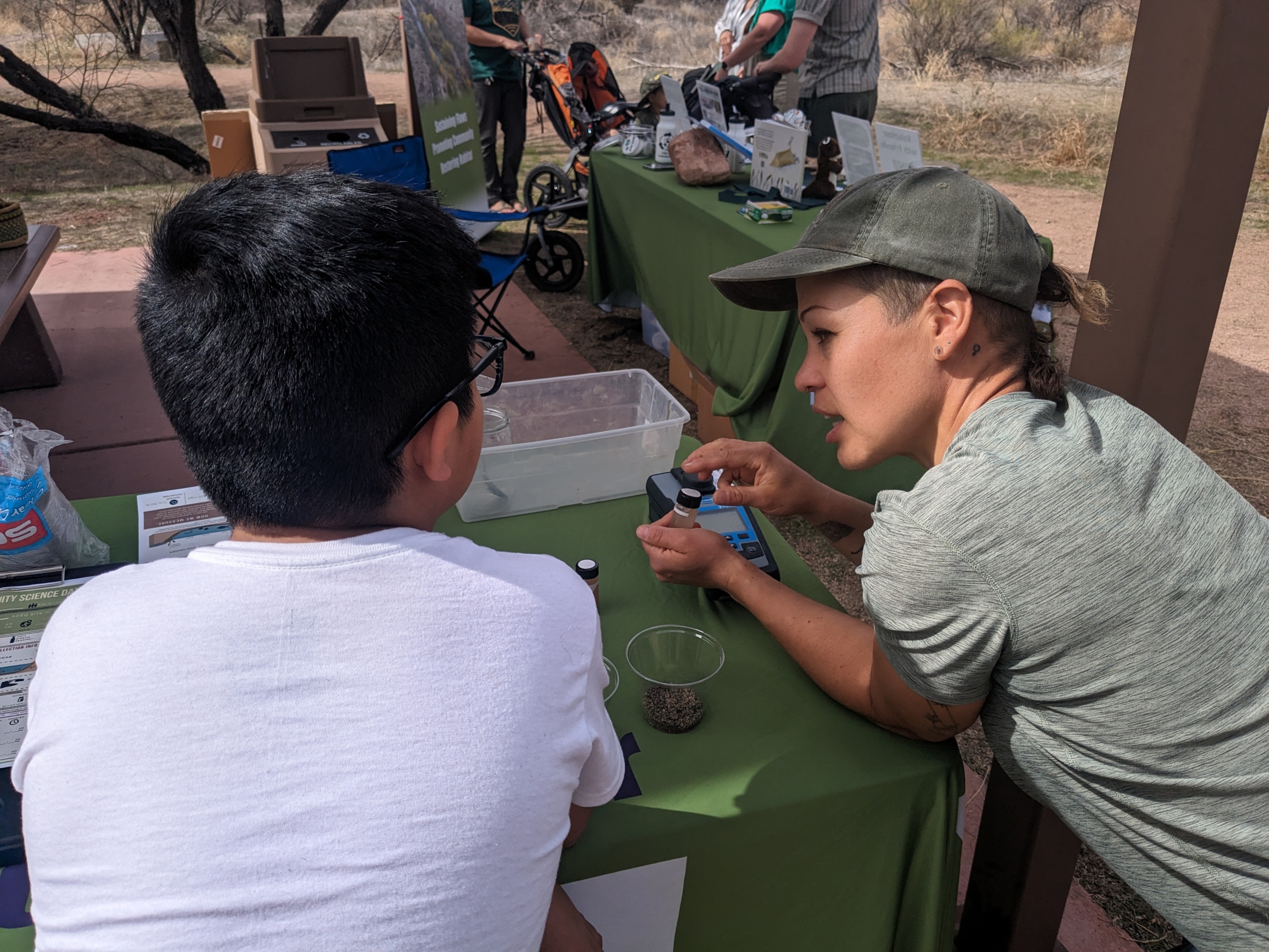 Cynthia showing water quality testing device to student