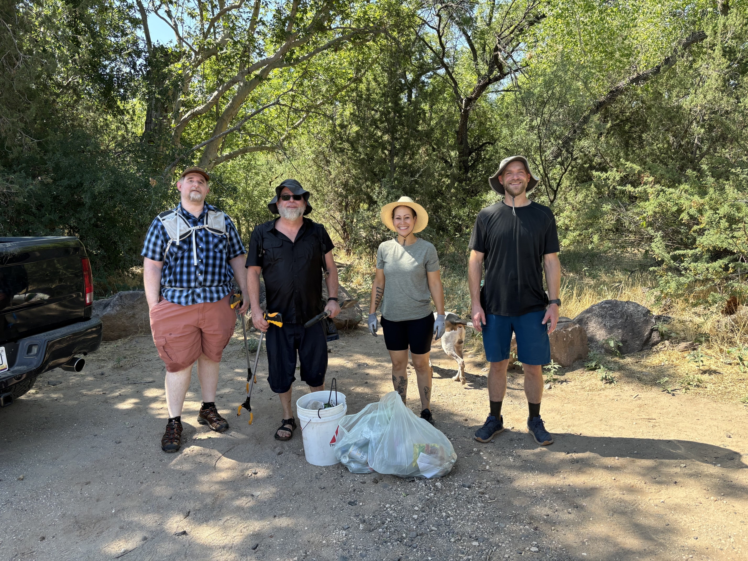 volunteers standing by bags of trash they cleaned up